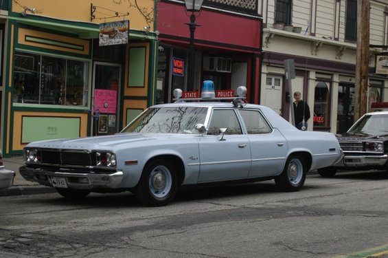 1973 Dodge 1500 police car parked on street, light blue with "STATE POLICE" light bar