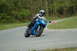 2007 Kawasaki Ninja R - A blue sportbike motorcycle with a rider navigates a turn on a track, with an orange cone visible nearby.