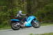 2007 Kawasaki Ninja R - A rider on a blue 2007 Kawasaki Ninja R motorcycle navigates a turn on a tree-lined road.