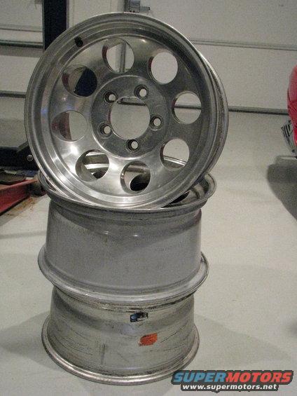 stack of three aluminum wheels, one on top with holes