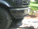 1995 Ford Bronco - Front view of a black Ford Bronco, showing the bumper, tire, and grille detail.