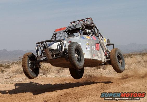 Silver off-road buggy mid-air, number 2036 visible on roof