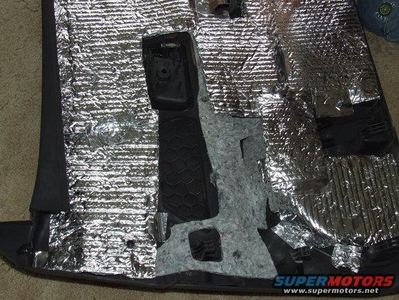 Car door panel with sound deadening material and black plastic trim