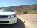 1997 Ford Probe - Front view of a white Honda parked on a gravel lot with desert vegetation and hills.