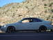 1997 Ford Probe - Side view of a white coupe parked on the side of a road with a mountain backdrop.