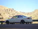 1997 Ford Probe - A white Honda Civic coupe is parked on the side of a road with a mountainous landscape behind it.