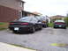 1997 Mazda MX-6 - Three vehicles are parked on a gravel driveway in front of houses.