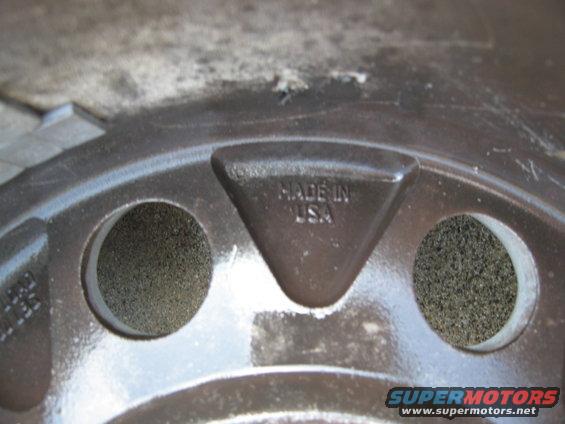 Dark metal wheel with "MADE IN USA" embossed on a triangular section