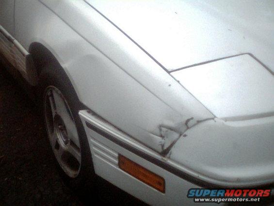 White car front corner with damaged fender and bumper