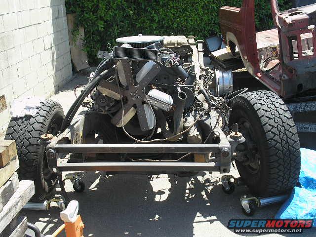 1986 Ford Bronco chassis with engine and front suspension visible. Body is partially removed