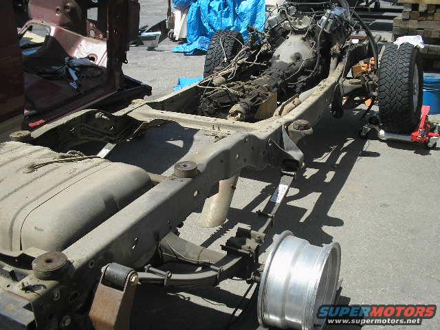 Vehicle chassis with engine and fuel tank removed, front wheel detached