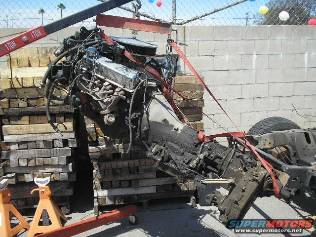 Engine and transmission assembly suspended by straps and hoist