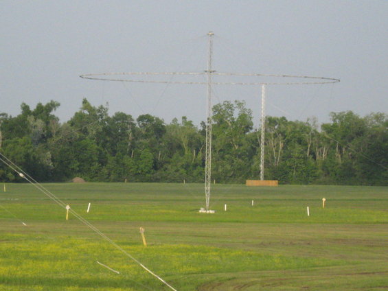 Radio towers with large circular antennas in a grassy field