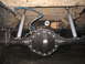 1979 Ford Bronco - Underside view of a vehicle's rear axle, leaf springs, and dual shock absorbers, with visible brake lines and air suspension components.