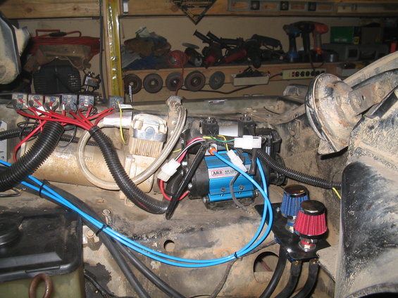 ARB air compressor and associated plumbing and wiring components mounted in engine bay