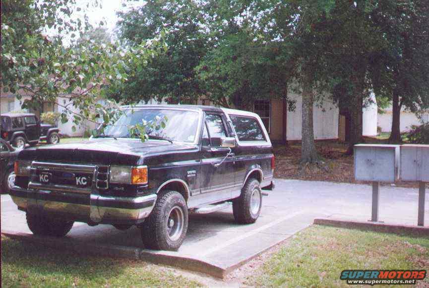 Black 1990 Ford Bronco 3/4 front view parked next to a Jeep