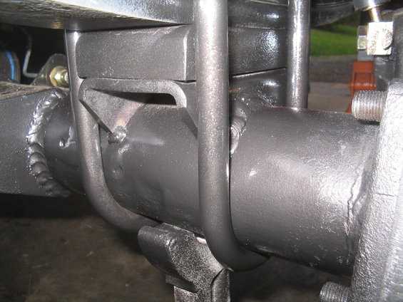 Close-up of rear axle U-bolt and spring plate with visible welds