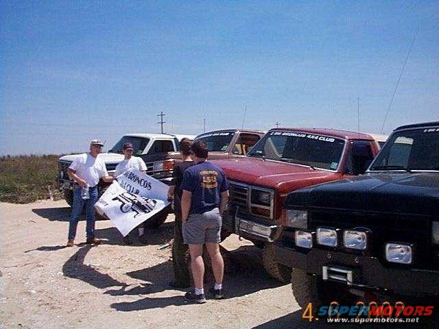 1990 Ford Bronco club members holding a banner with a Bronco graphic