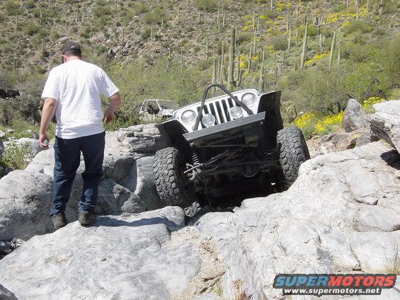 White Jeep Wrangler navigating rocky terrain