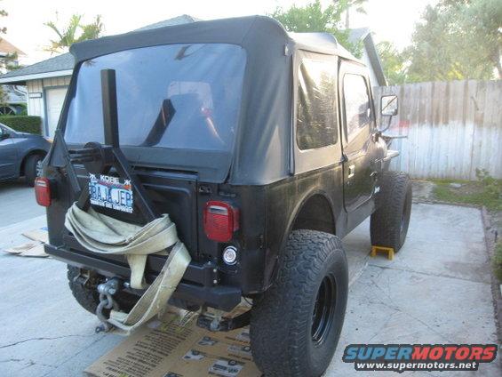 Black Jeep CJ7 rear view with soft top and spare tire mount