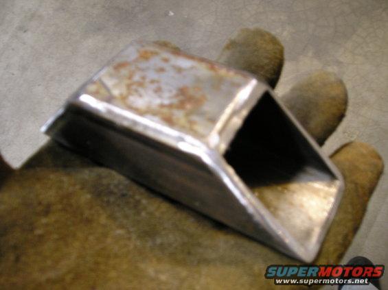 Metal bracket with rust held in a gloved hand
