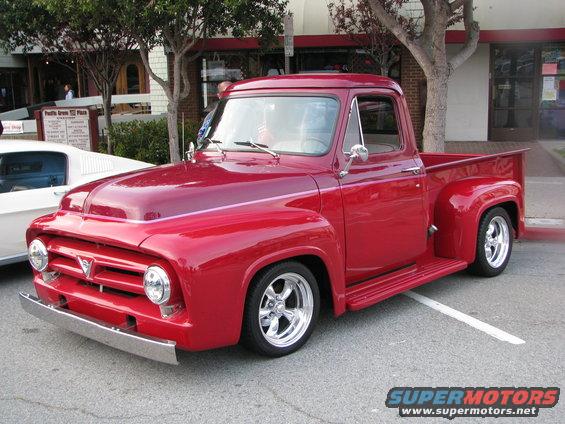 Red 1956 Ford F-100 pickup truck parked on street