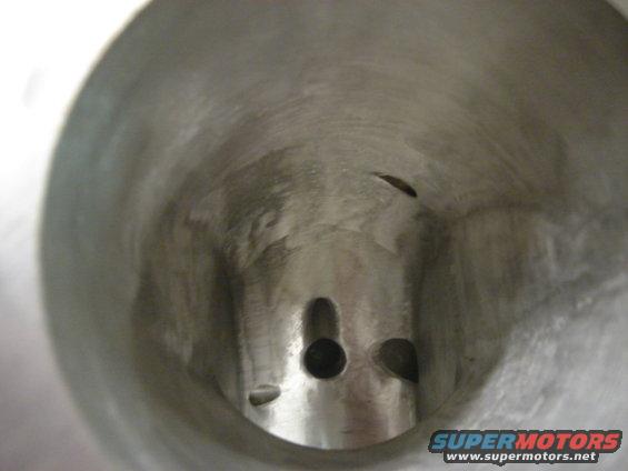 Inside of a metal intake manifold with visible ports and machining marks