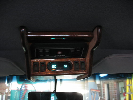 Overhead console with wood trim, climate controls showing 72F, and a Centurion branded radio