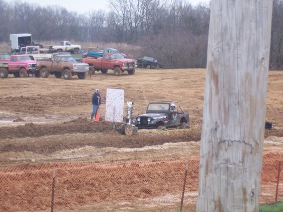 Black jeep stuck in mud with "Wild Country" sticker on door