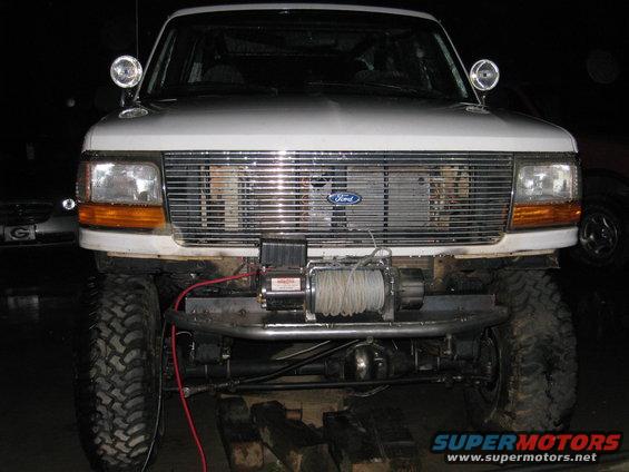 White Ford Bronco front end with chrome grille, winch, and aftermarket bumper