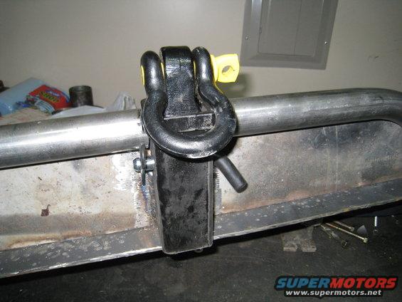 Tow hitch shackle attached to a metal bumper