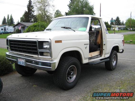 White 1980 Ford Bronco parked in driveway, driver door open
