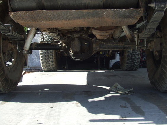Underside view of a vehicle's rear axle, leaf springs, and fuel tank