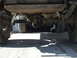 1978 Jeep Cherokee - The underside of a vehicle shows its rear axle assembly, suspension components, and a portion of the fuel tank.