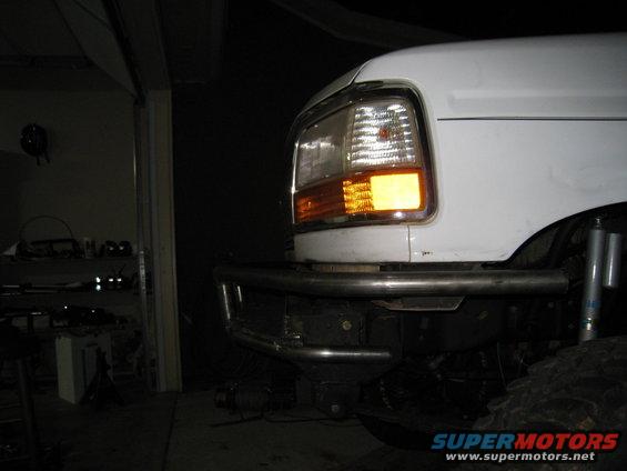 White Ford truck front end with aftermarket bumper and amber turn signal