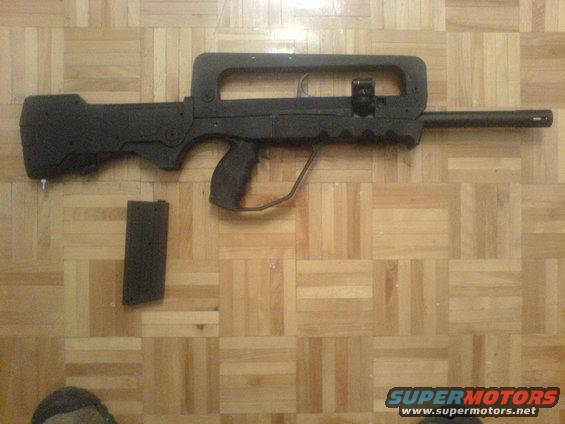 Black rifle and magazine on wood floor