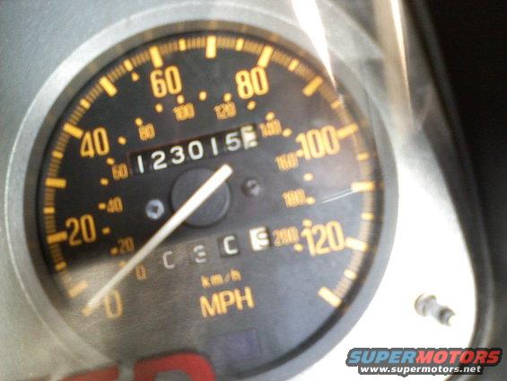 Speedometer reads 123015. Tachometer shows 0-8000 RPM