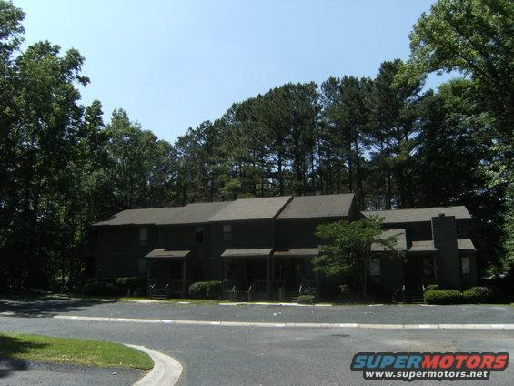 Apartment buildings with trees and a road in front