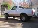 1996 Ford Bronco - This white Ford Bronco, likely from the early to mid-1990s, is shown with its soft top removed and a tan accent stripe.