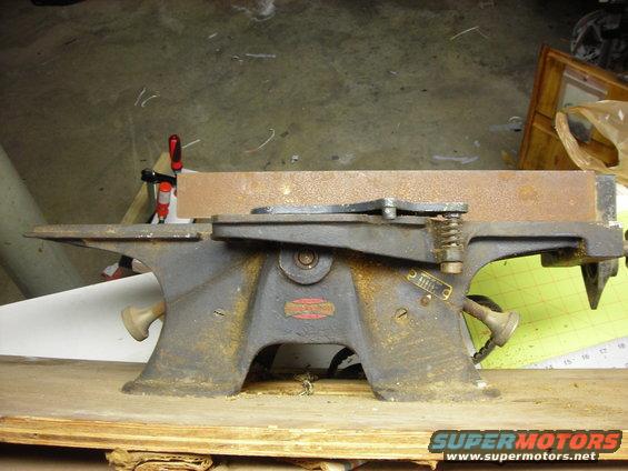 Side view of a rusty shop tool with a red label