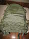 1991 Ford Bronco - A green tactical backpack with multiple straps and buckles is shown against a wooden floor background.