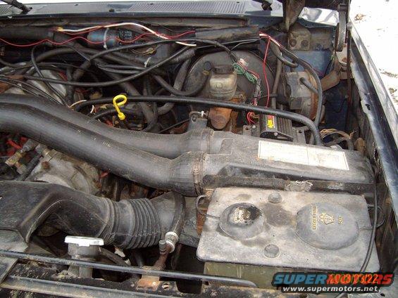 Engine bay with hoses and wiring visible. Supermotors.net logo at bottom right