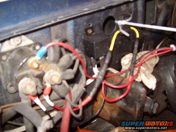 Engine bay wiring with red and yellow wires connected to a junction block, blue and red wire connectors visible
