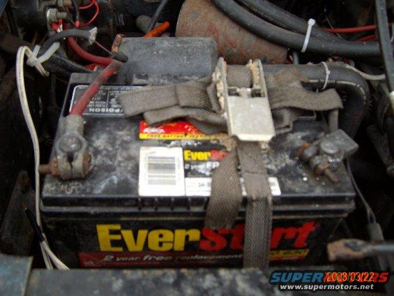 Car battery with "EverStart" label and "2 year free replacement" text, secured by a strap