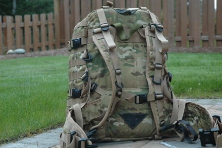 Camouflage backpack with multiple straps and compartments, seen from the side
