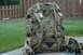 1991 Ford Bronco - A camouflage backpack is shown outdoors with a blurred background of grass and a fence.