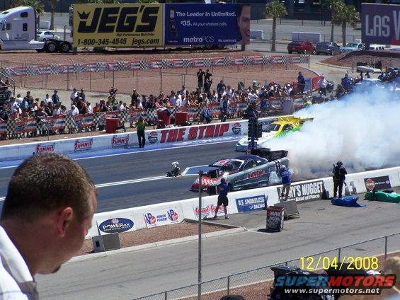 Drag racing cars with smoke on the track, JEG'S billboard in background