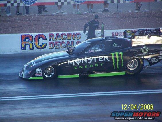 Black drag car with Monster Energy livery, side view