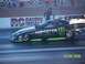 1973 Ford Mustang - A drag racing car with Monster Energy branding speeds down the track.