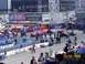 1973 Ford Mustang - A busy drag racing event with multiple vehicles and a crowd of spectators.